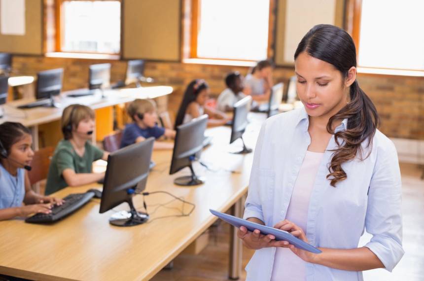 A woman is holding her tablet in front of some people.