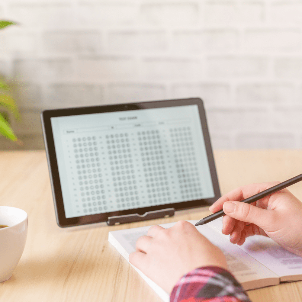 A person is writing on paper while sitting at a table.