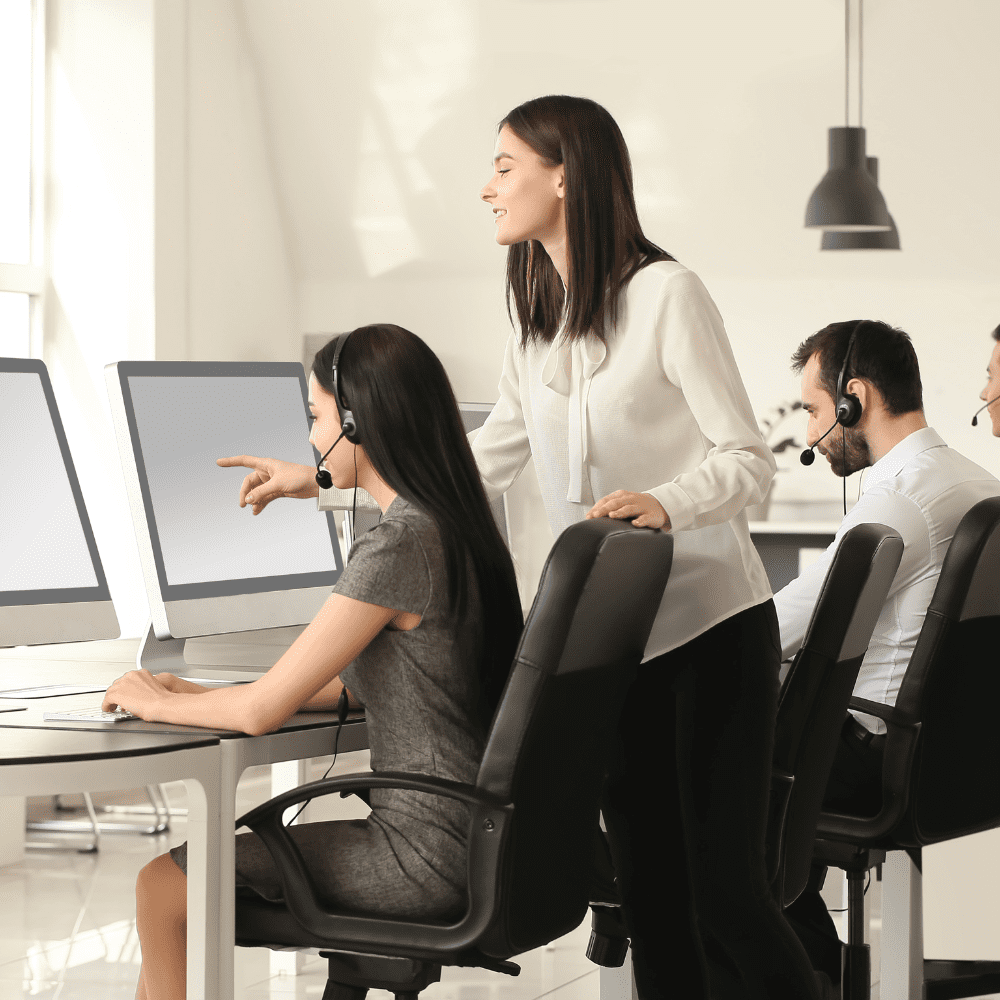 A group of people sitting at computers in an office.