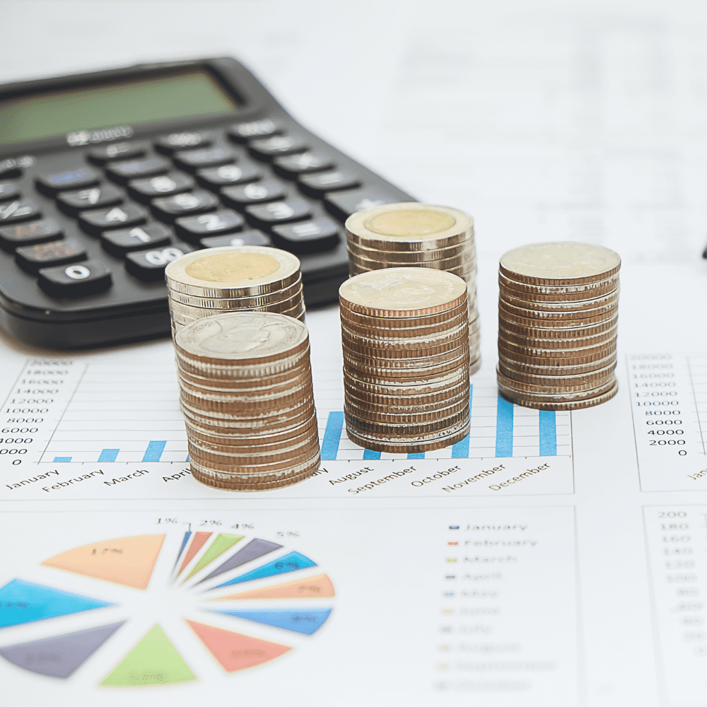 A calculator and some coins on top of a table.