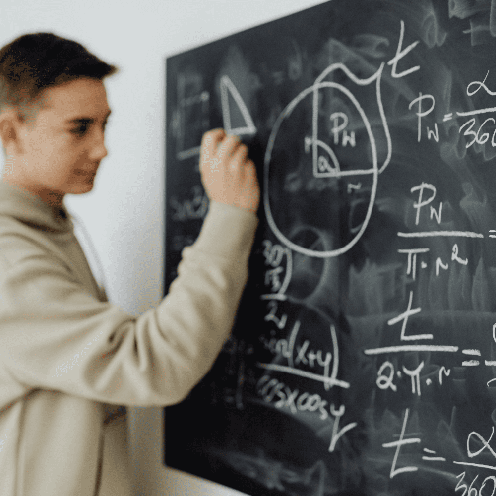 A man writing on the board with chalk