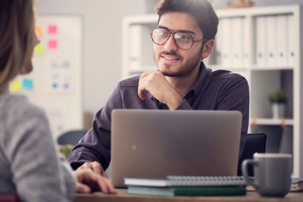 A man sitting at a table with his laptop.