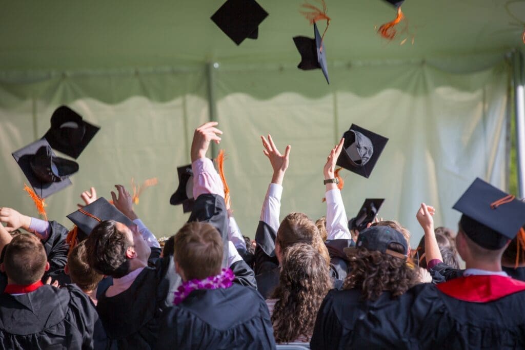 A group of people in graduation attire throwing their hats.