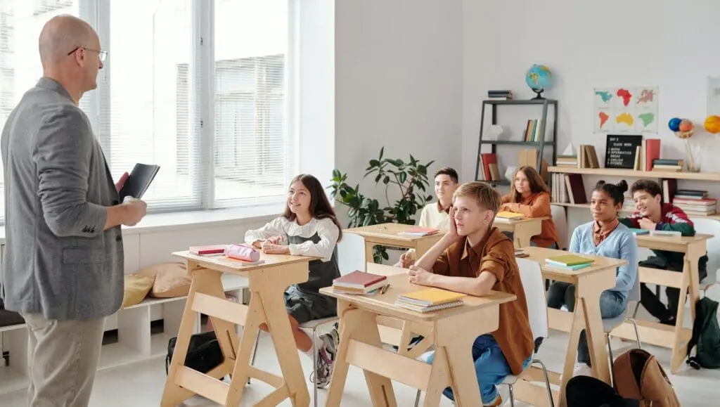 A group of people sitting at desks in a classroom.