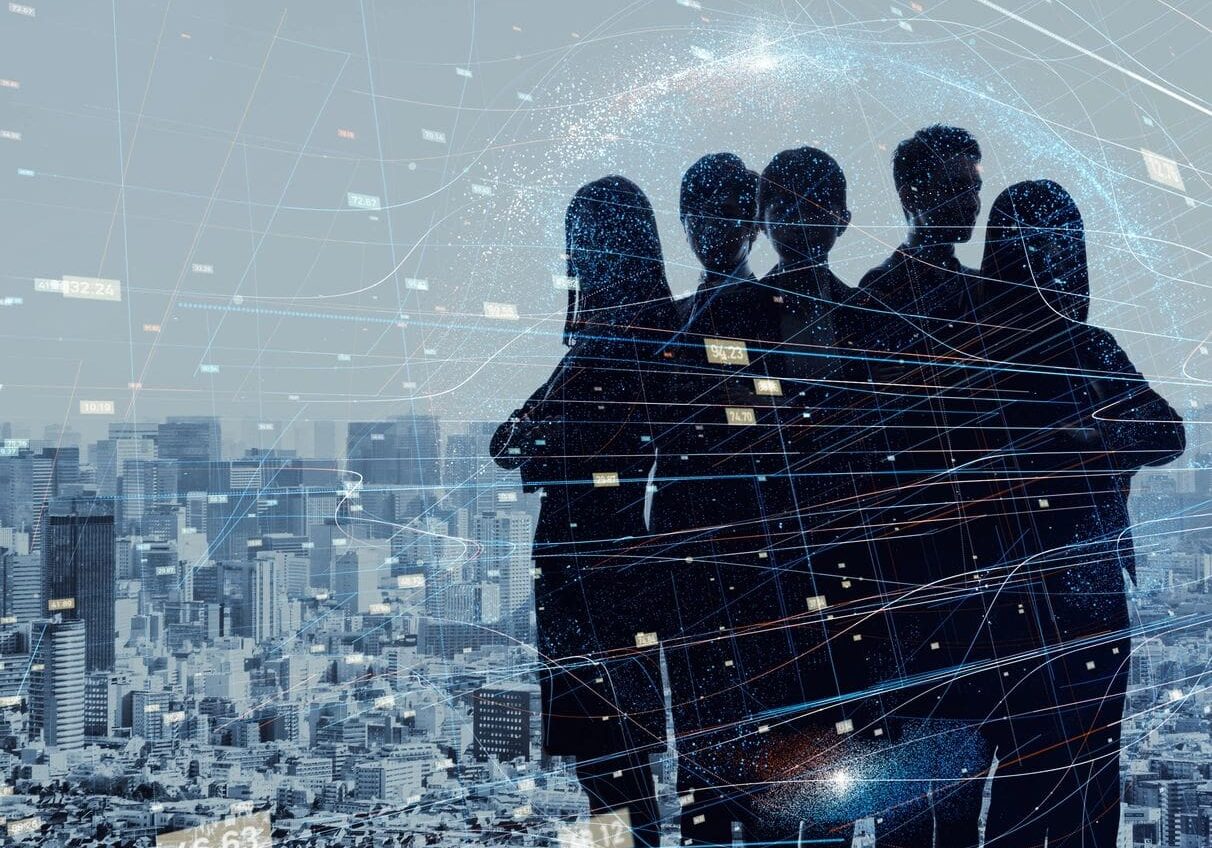 Silhouettes of four business people overlaid on a cityscape with digital network connections and data points.